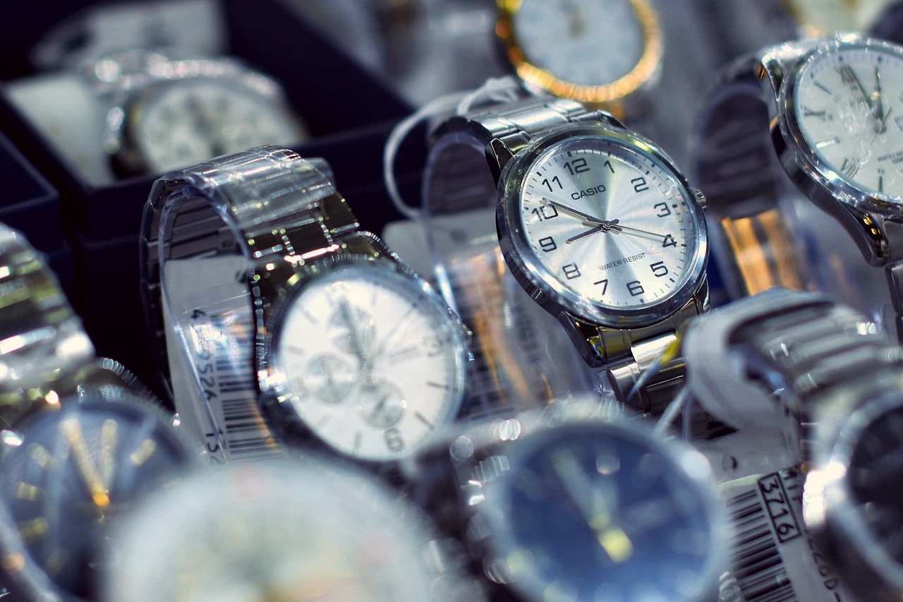 A close-up of several wristwatches with silver and gold designs on display in a store