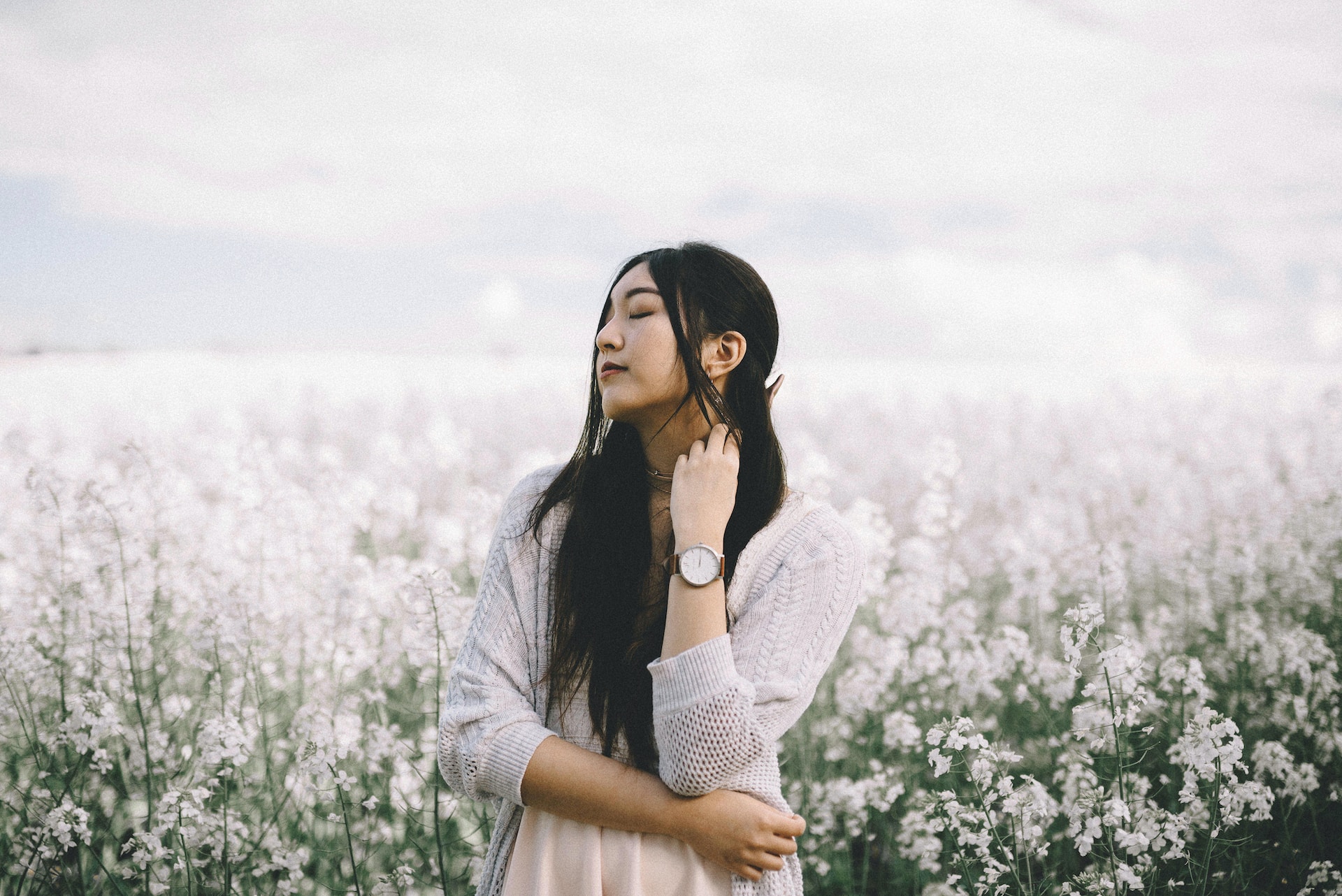 lady wearing a watch standing in a field of flowers