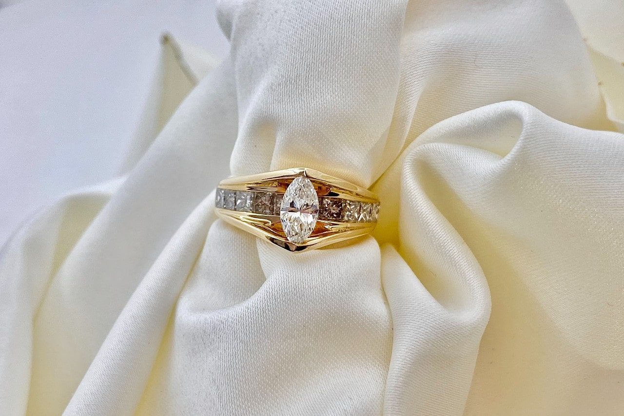 a thick banded marquise engagement ring on a piece of white cloth
