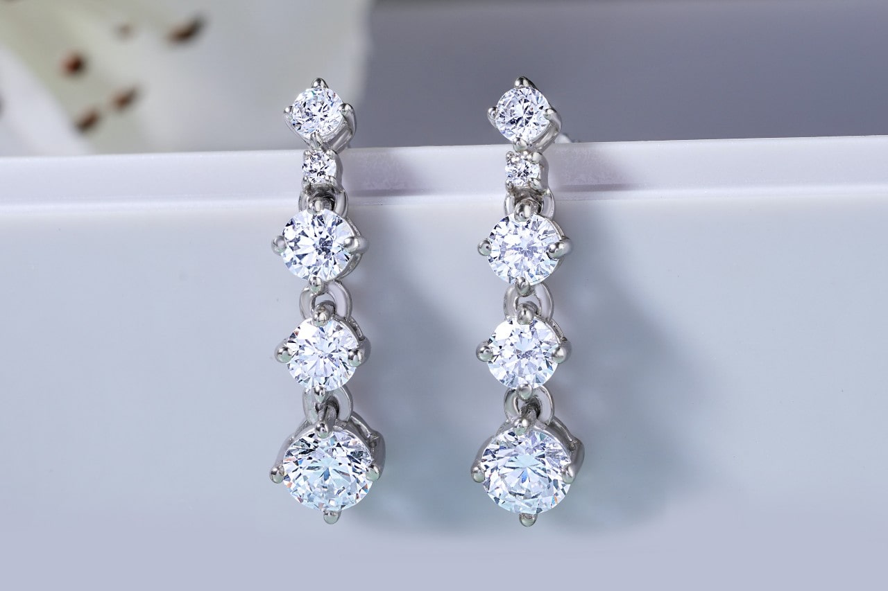 a pair of silver, diamond, four-tiered earrings