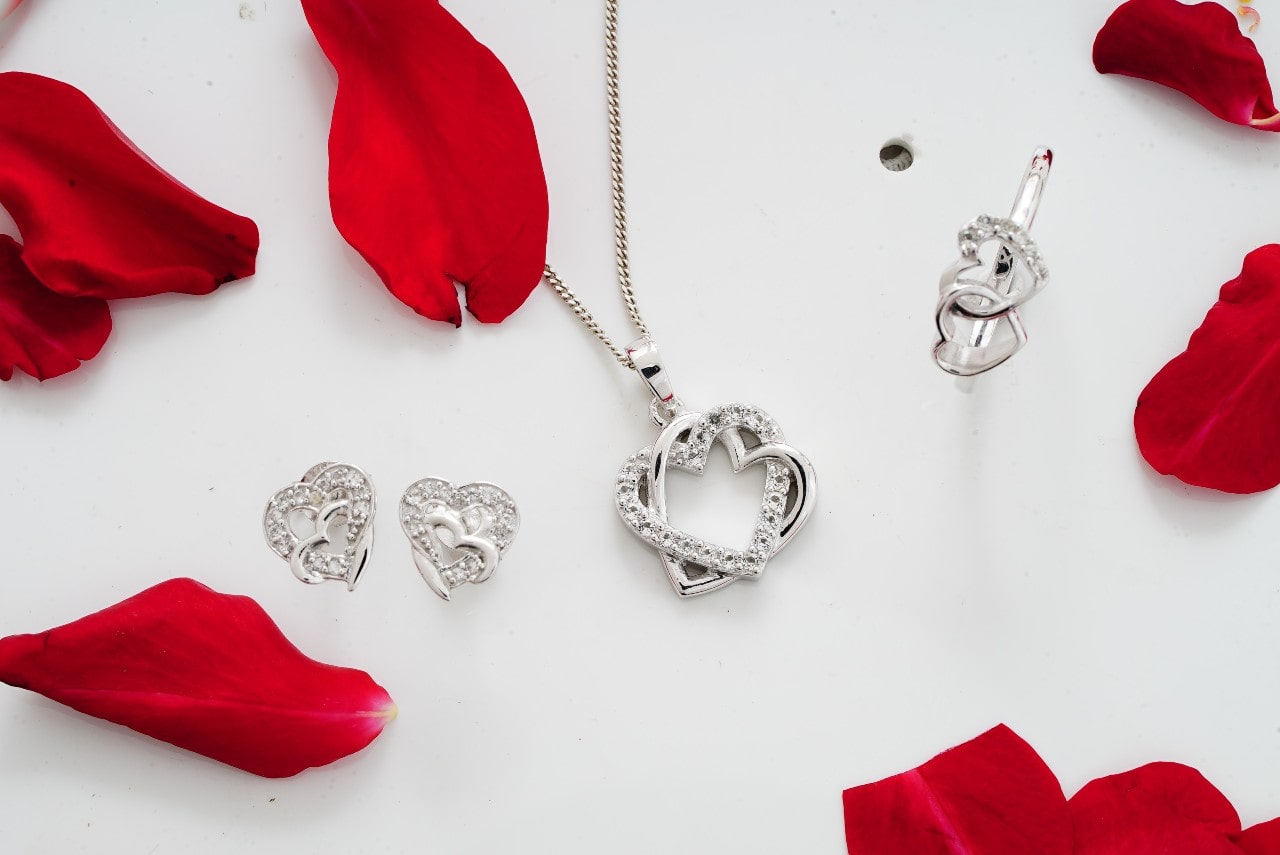 diamond jewelry on white background with rose petals diamond jewelry on white background with rose petals